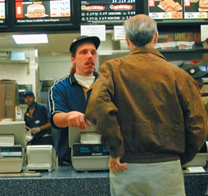 Cashier Duane Hesketh and customer Robert Lalley eye each other with disgust.